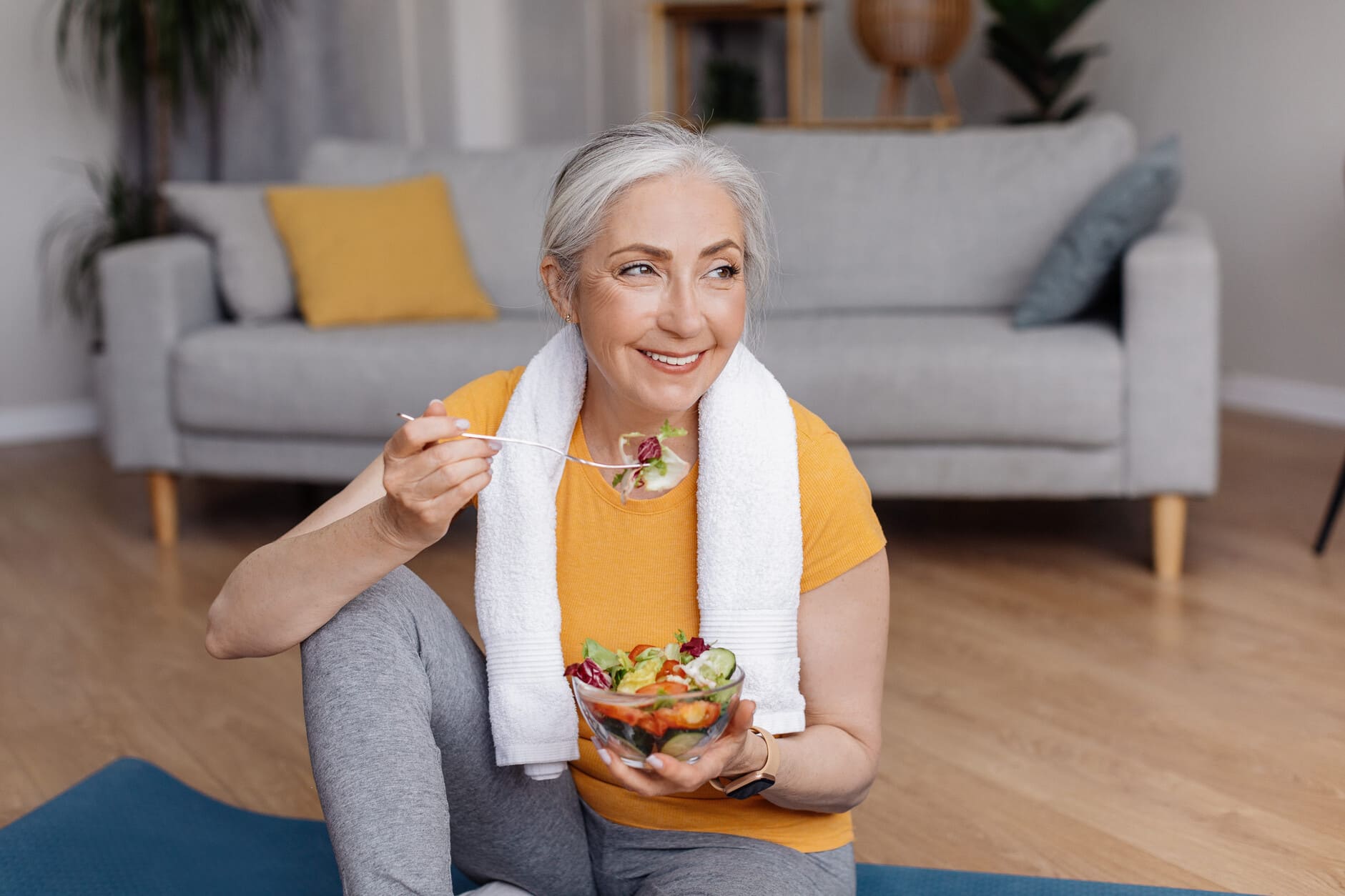 Mujer mayor disfrutando una alimentación saludable después de hacer ejercicio, representando hábitos de biohacking respaldados por la evidencia científica para promover un envejecimiento saludable.