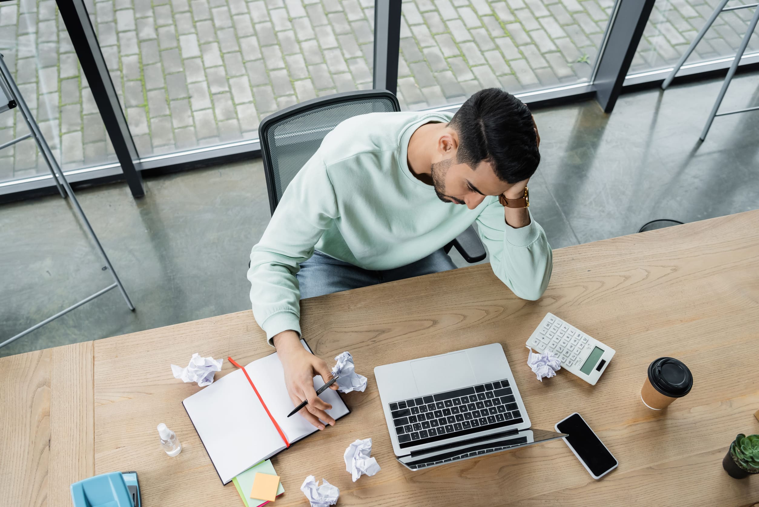 Hombre agotado física y emocionalmente en su lugar de trabajo.