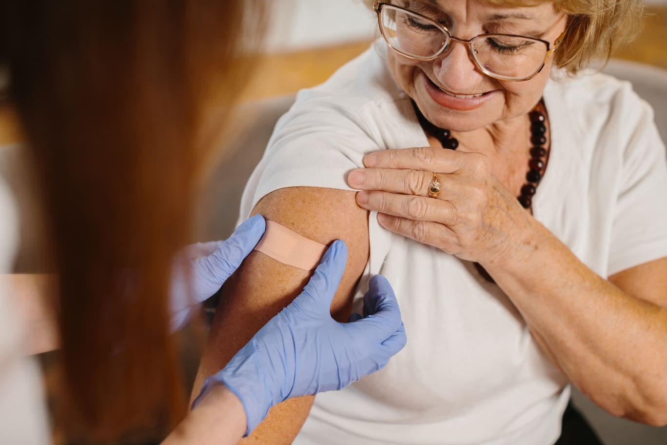 Mujer adulta mayor después de la vacunación por un profesional de la salud.