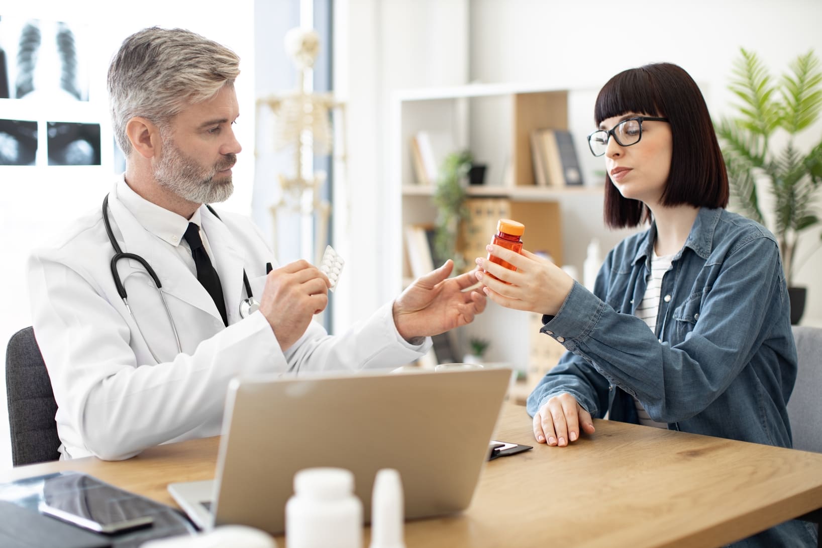 Médico explicando a una paciente el uso correcto de un medicamento durante una consulta médica