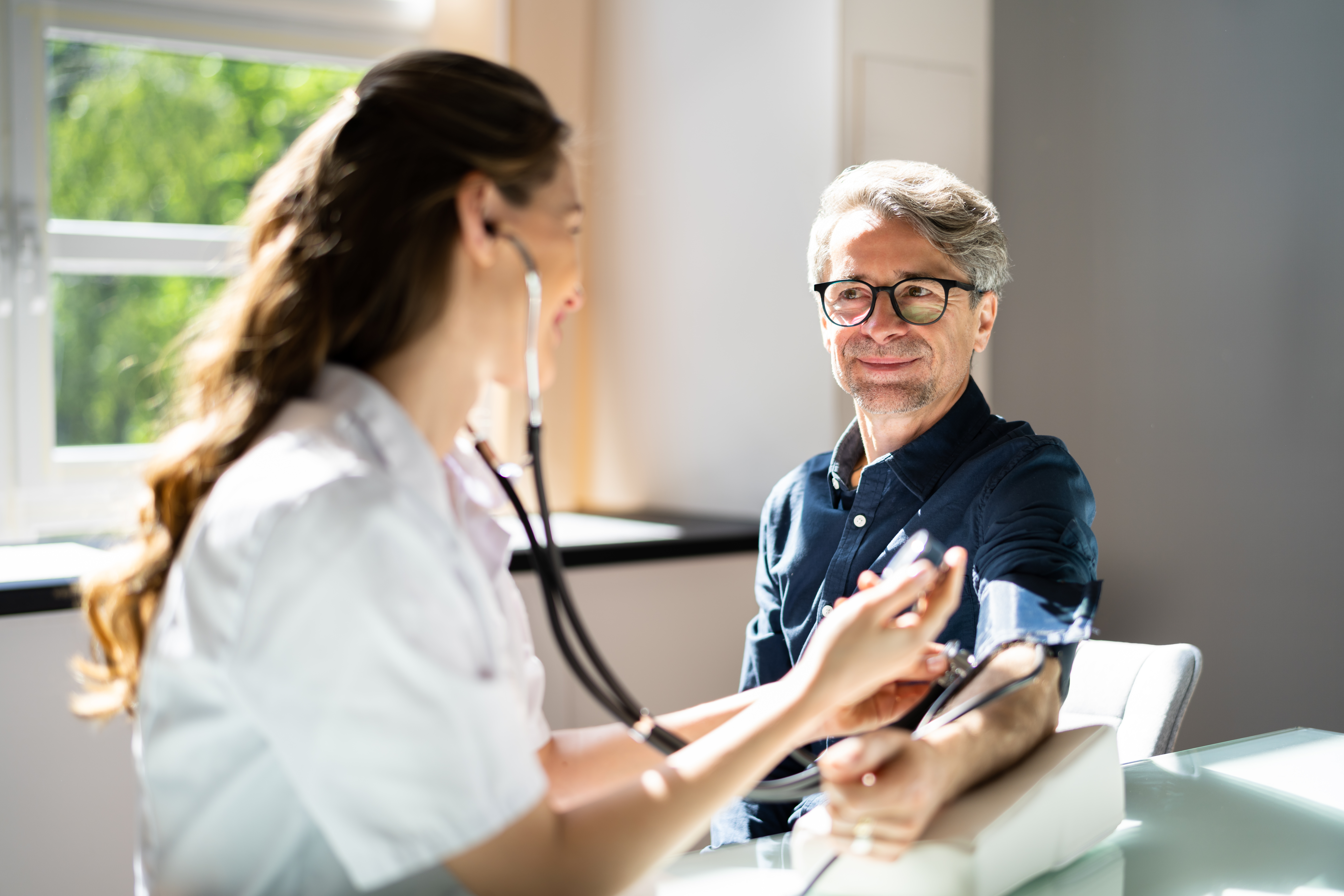 Paciente tomándose la presión arterial durante una consulta médica