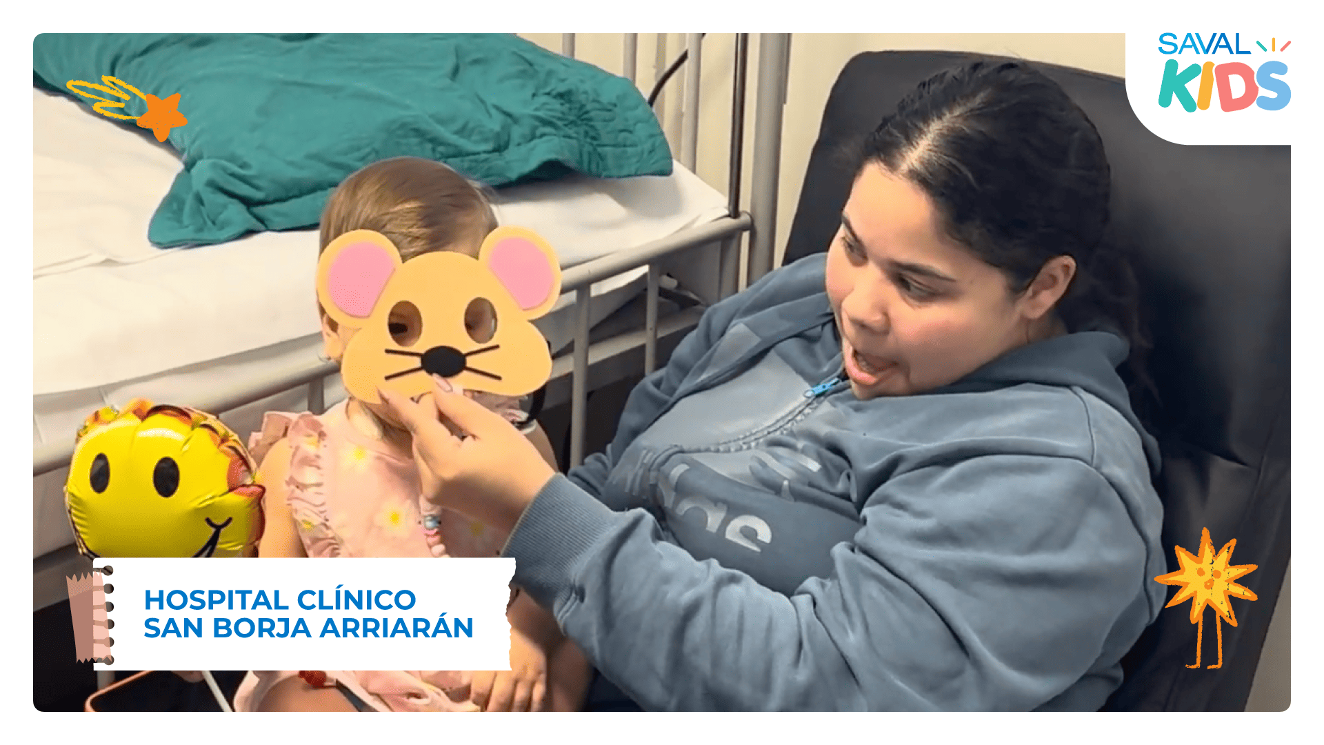 Una mujer juega con una niña sosteniéndole una máscara de cartulina junto a una cama de hospital, durante SAVAL Kids en el Hospital San Borja Arriarán.